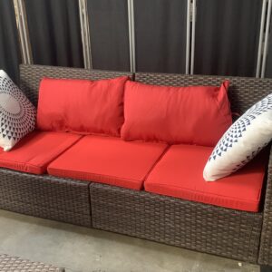 Brown resin wicker three seat outdoor couch with red cushions