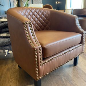 28.5” H leather look brown studded barrel chair.